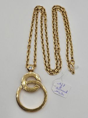 a close up of a gold chain with a ring on it