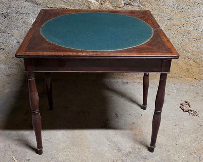 une petite table au plateau bleu posée sur un sol en béton