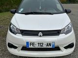 l'avant d'une voiture blanche garée sur un chemin de gravier