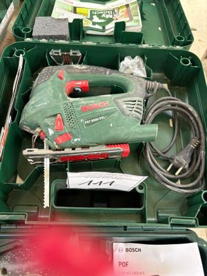 une boîte verte contenant des outils, posée sur une table