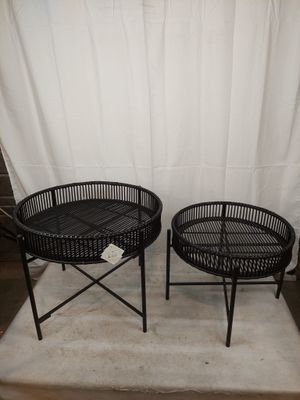 deux chaises en osier noir et une table devant un fond blanc