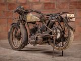 a old motorcycle that is parked in front of a brick wall