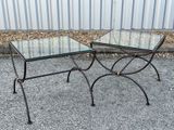 pair of glass and iron side tables on a gravel ground