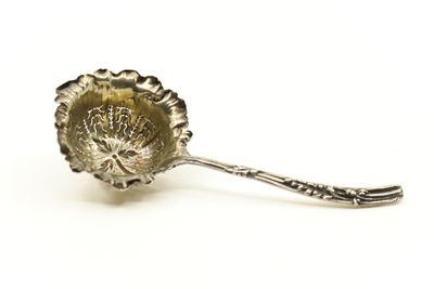 cuillère plaquée argent, ornée d'un motif floral sur fond blanc