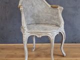 une chaise blanche avec une assise en osier posée sur un sol en bois