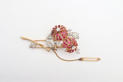 un gros plan sur une broche rose et dorée ornée de perles