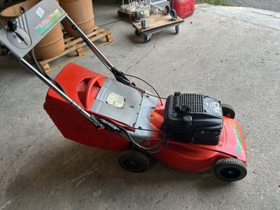 a red lawn mower that is sitting on the ground