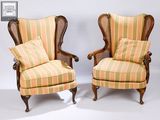 pair of antique cane back wing chairs with striped upholstered cushions