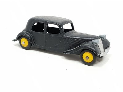 a black toy car with yellow wheels on a white surface