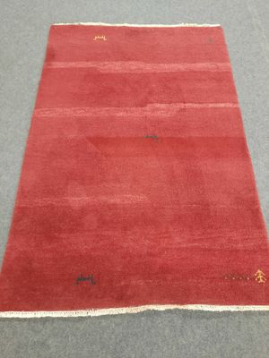 a red rug on a grey floor with a white border