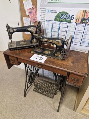 une machine à coudre posée sur une table sur laquelle se trouve un calendrier