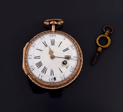 an old pocket watch and a key on a black surface