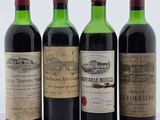 quatre bouteilles de vin sont alignées sur une surface blanche