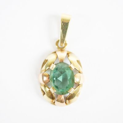 a close up of a green stone pendant on a white surface