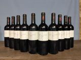 six bottles of wine are lined up on a wooden table