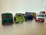 Plusieurs camions miniatures sont alignés en rang sur une table