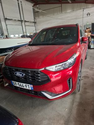 une voiture rouge garée dans un garage à côté d'un bateau
