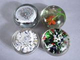 three glass bowls with different types of beads in them