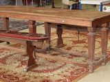une table et un banc en bois dans une pièce où le sol est recouvert de tapis