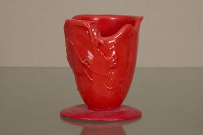 un vase rouge posé sur une table en verre