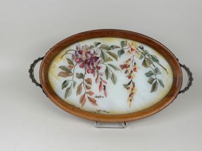 a tray with flowers and leaves on it on a stand