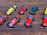 de nombreuses petites voitures miniatures alignées sur une table en bois
