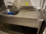 un évier de cuisine dans lequel se trouve un récipient bleu