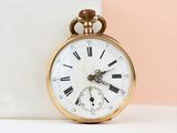 une montre de poche en or avec des chiffres romains