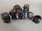 a camera and two lenses sitting on a table