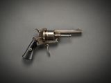 a close up of a gun on a table with a gray background
