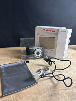 the camera is sitting on the table next to the box