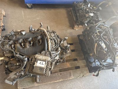un tas de pièces de moteur posées sur une palette dans un garage