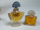 a small bottle of perfume next to a small bottle of perfume