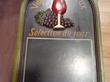 a plaque with a glass of wine on it on a table