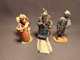 three figurines of men dressed in medieval clothing and holding weapons