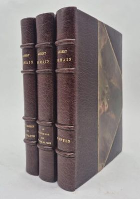 trois livres sont empilés sur une surface blanche