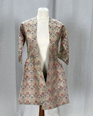 une photo d'un mannequin portant une veste à fleurs, posé sur un pied de mannequin