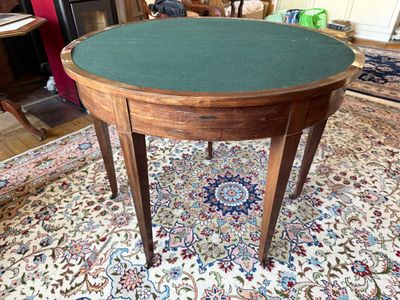 une table au plateau vert posée sur un tapis dans un salon