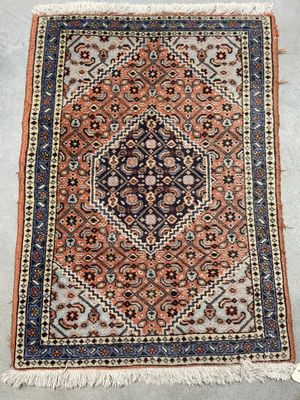 an antique persian rug with a geometric design and fringe fringes