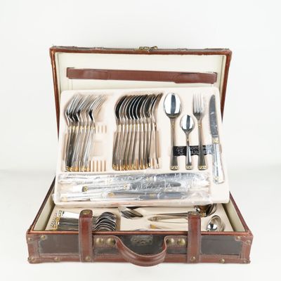 une valise contenant de l'argenterie, posée sur une surface blanche