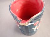 a red and blue vase sitting on a table