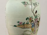 a vase with a painting on it sitting on a table