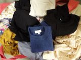 a pile of clothes sitting on top of a bed