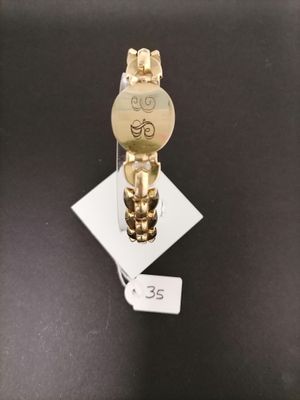 a gold watch on display on a black surface