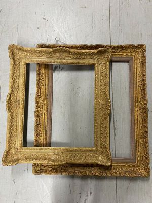 two gold framed mirrors sitting on top of a white wooden floor
