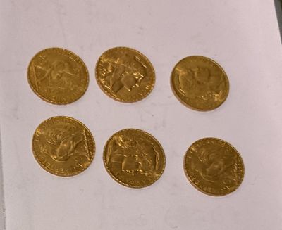 six gold coins are arranged in a row on a white surface