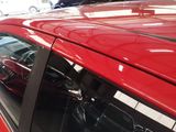 a red car parked in a parking lot with other cars