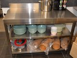 une table en acier inoxydable sur laquelle sont posées des assiettes et des bols
