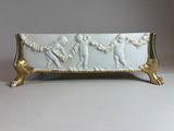 an image of a white and gold plate with figures on it