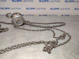 a chain with a clock attached to it on a table